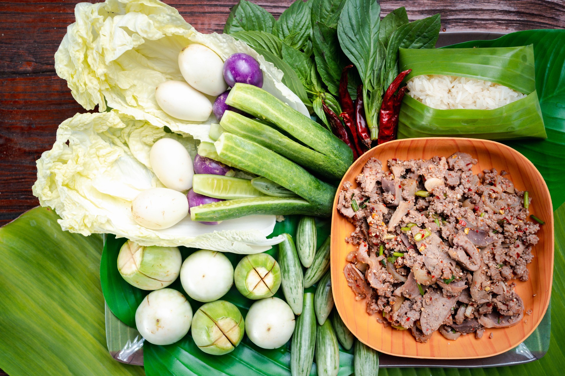 Authentic Thai Street Flavor Spicy Minced Pork Salad Presentation on Banana Leaf and Traditional Cloth