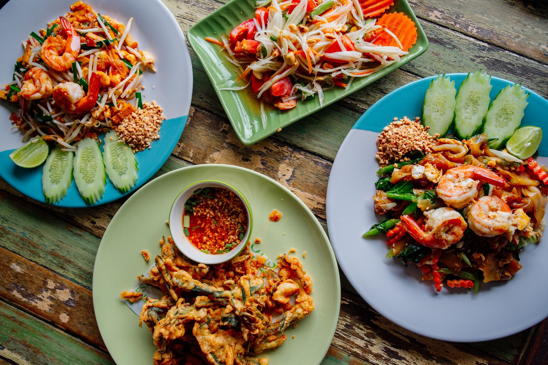 Traditional Thai dishes: pad thai with shrimps, som tam salad and stir fried morning glory