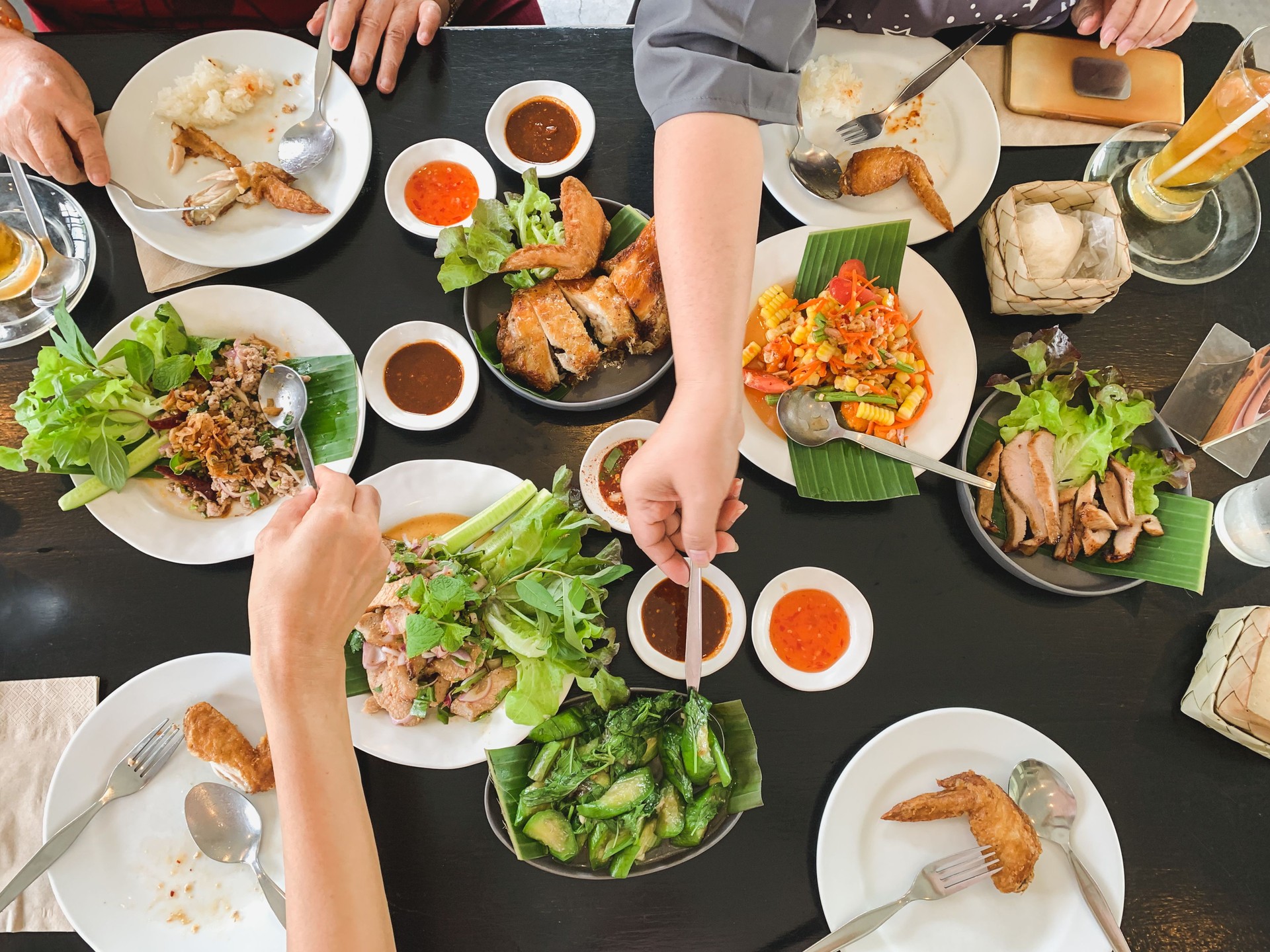 Top view of family eating food together at lunch time.