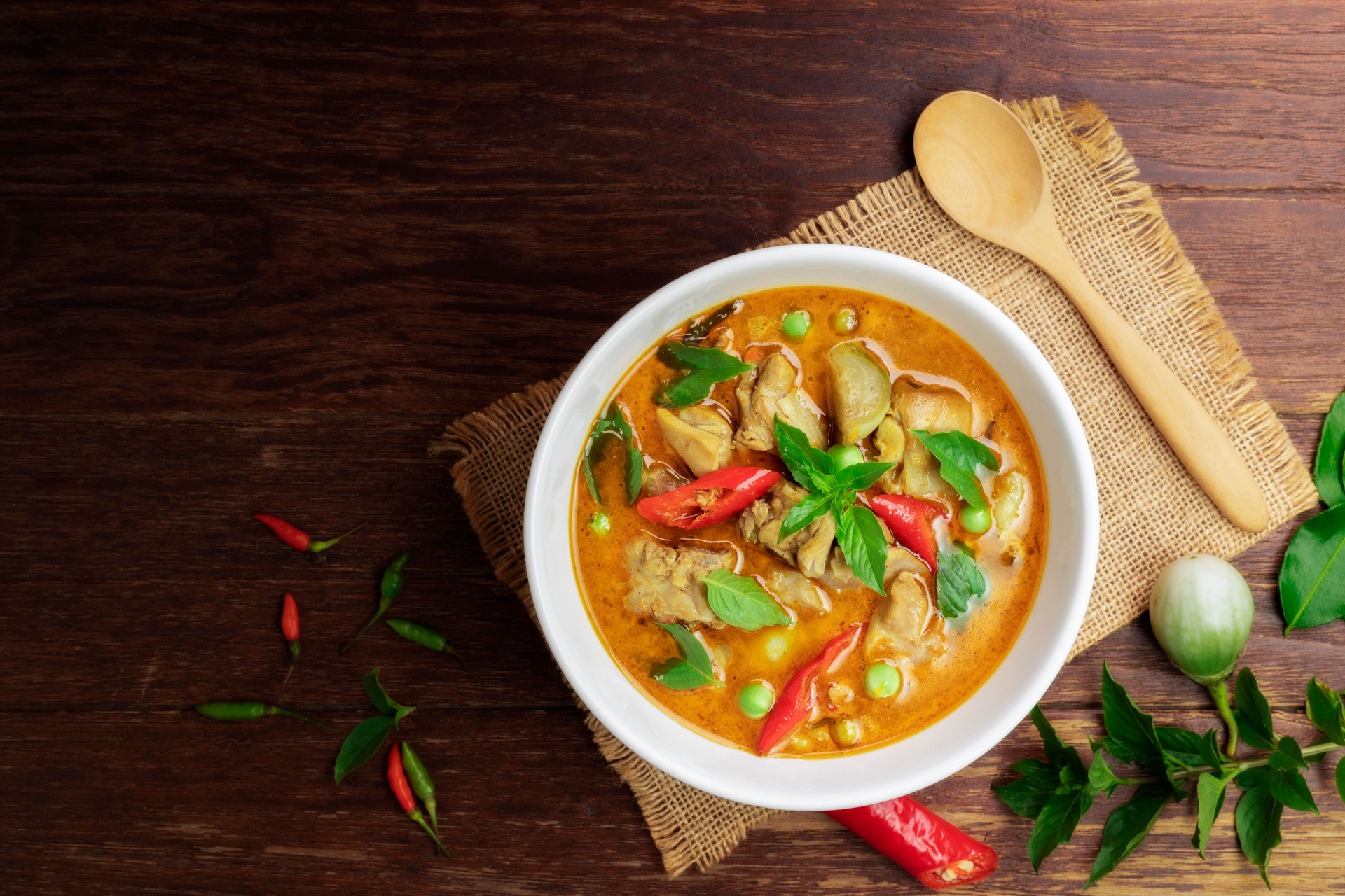 Chicken green curry Asian food, Beef green curry Thai food on a soup bowl with a mixture of herbs, vegetables and Thai red chilli spices. Top view.
